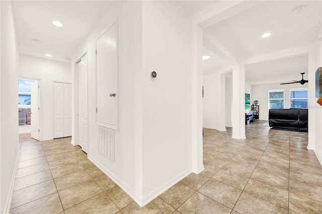 hall with a healthy amount of sunlight and light tile patterned flooring