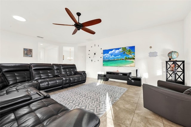 tiled living room with ceiling fan with notable chandelier