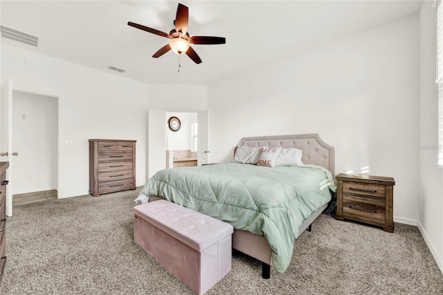 bedroom with ceiling fan, light carpet, and ensuite bath