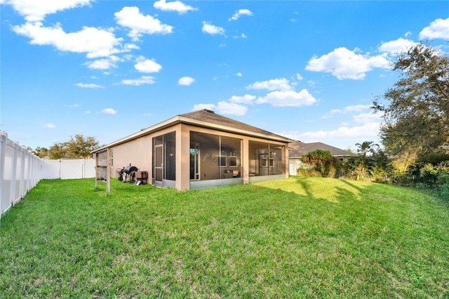 back of house with a lawn and a sunroom