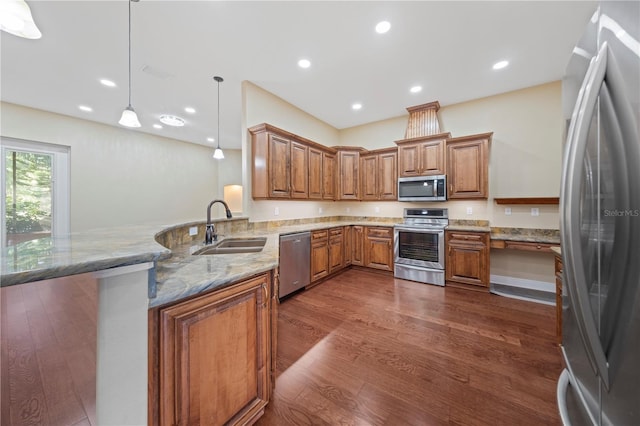 kitchen with kitchen peninsula, dark hardwood / wood-style flooring, stainless steel appliances, sink, and decorative light fixtures