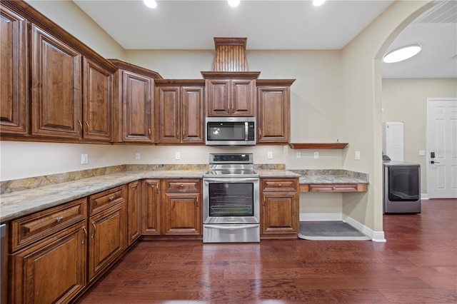 kitchen with light stone counters, dark hardwood / wood-style flooring, and appliances with stainless steel finishes