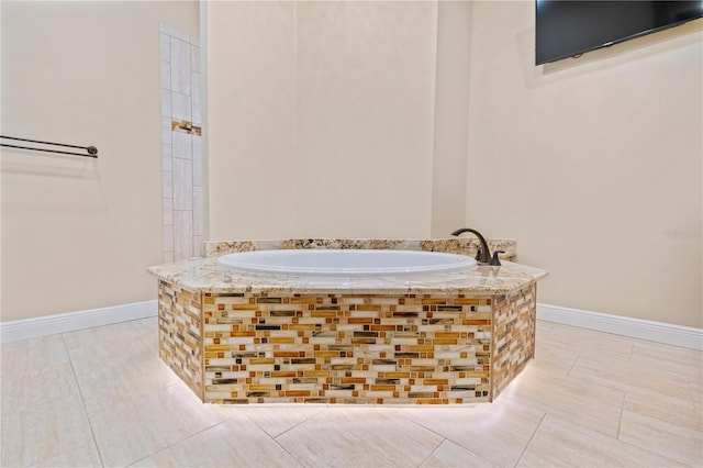 bathroom featuring tile patterned flooring and a relaxing tiled tub