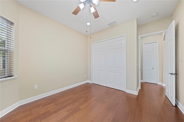 unfurnished bedroom featuring a closet, hardwood / wood-style flooring, and ceiling fan