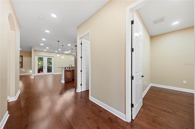 corridor featuring french doors and dark hardwood / wood-style flooring