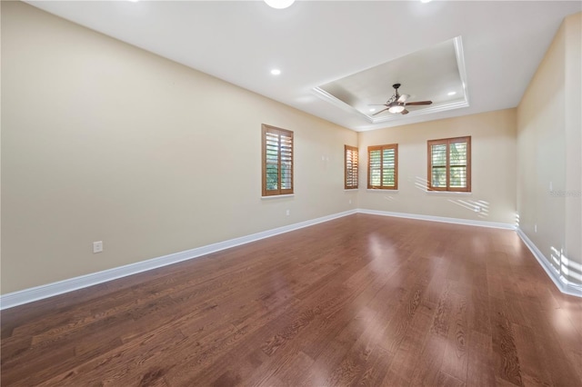 unfurnished room with a tray ceiling, ceiling fan, and hardwood / wood-style flooring