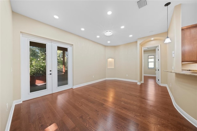 unfurnished room with french doors, a wealth of natural light, and dark wood-type flooring