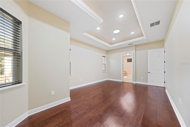 unfurnished room featuring dark hardwood / wood-style flooring, a raised ceiling, and ornamental molding