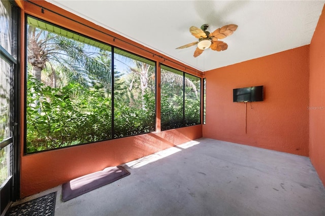 unfurnished sunroom featuring ceiling fan