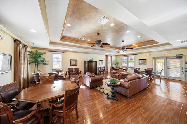 living room with a tray ceiling, ceiling fan, hardwood / wood-style floors, and crown molding