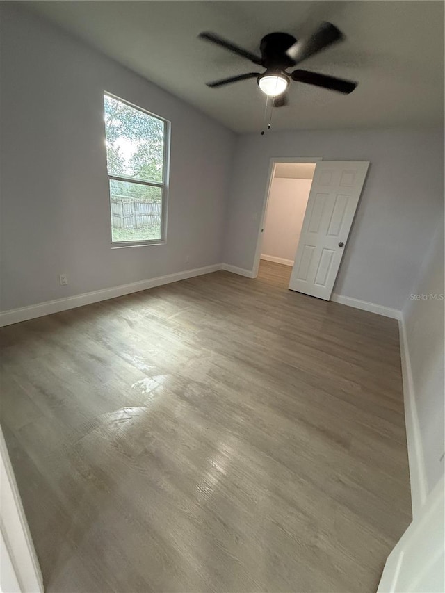 empty room with ceiling fan and hardwood / wood-style floors