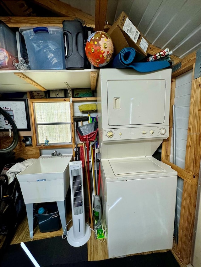 laundry area with sink and stacked washer / drying machine