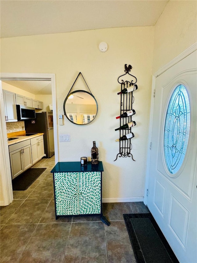 foyer featuring dark tile patterned floors