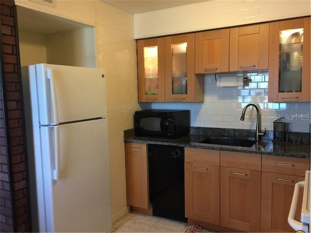 kitchen with dark stone counters, decorative backsplash, sink, and black appliances