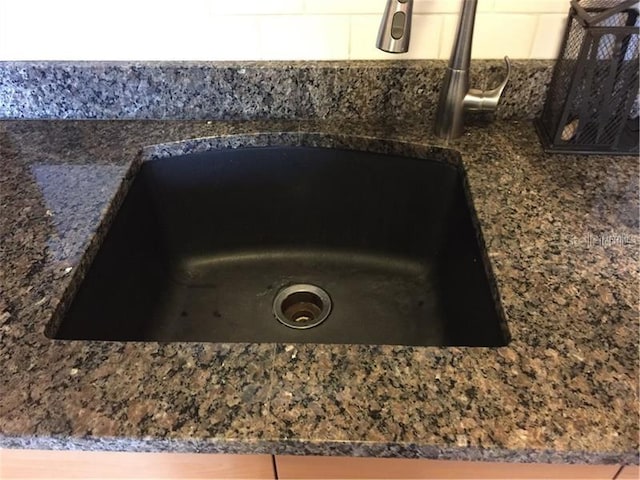 room details featuring sink and dark stone counters