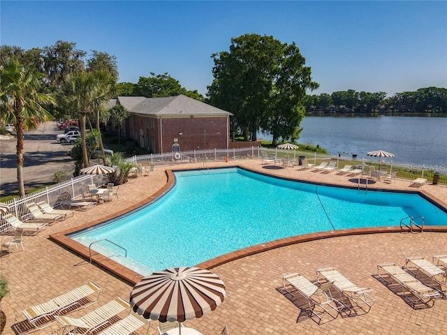 view of swimming pool with a patio area and a water view