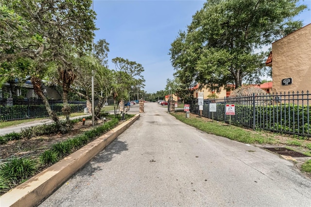 view of road featuring curbs and a gated entry