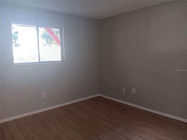 empty room featuring wood finished floors and baseboards