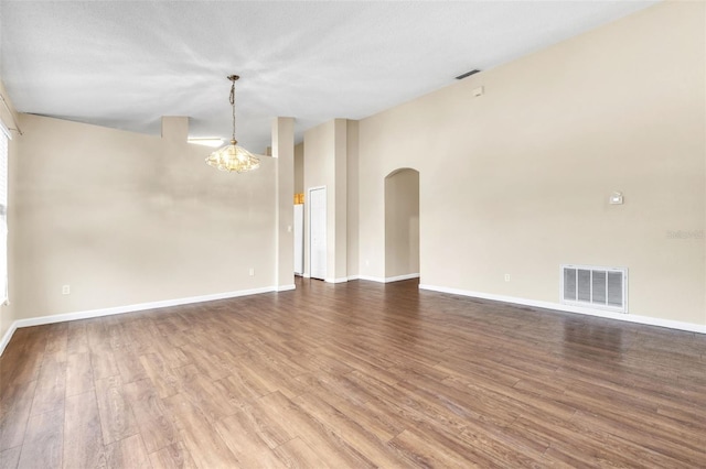 spare room featuring hardwood / wood-style floors, a textured ceiling, and a chandelier