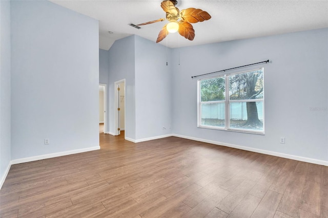 unfurnished room with vaulted ceiling, ceiling fan, and light hardwood / wood-style flooring