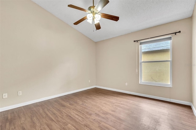 unfurnished room featuring hardwood / wood-style flooring, ceiling fan, lofted ceiling, and a textured ceiling