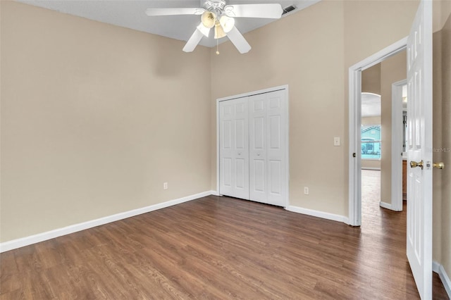 unfurnished bedroom featuring ceiling fan, dark hardwood / wood-style floors, and a closet