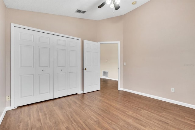 unfurnished bedroom featuring ceiling fan, light hardwood / wood-style floors, and a closet