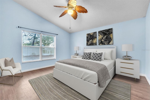 bedroom featuring hardwood / wood-style floors, vaulted ceiling, and ceiling fan