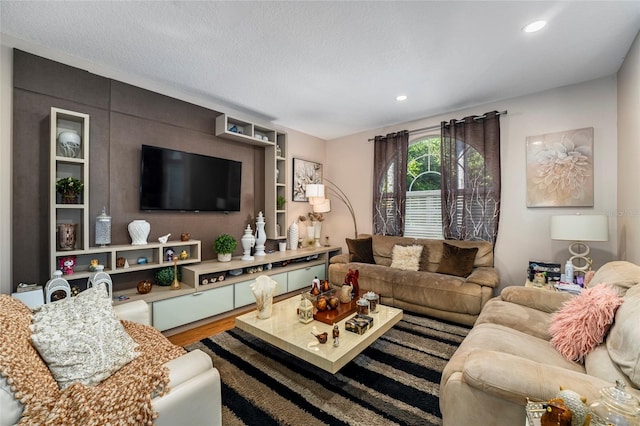 living room featuring wood-type flooring and a textured ceiling