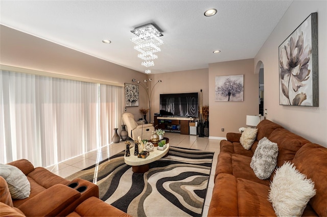 tiled living room featuring a textured ceiling and an inviting chandelier