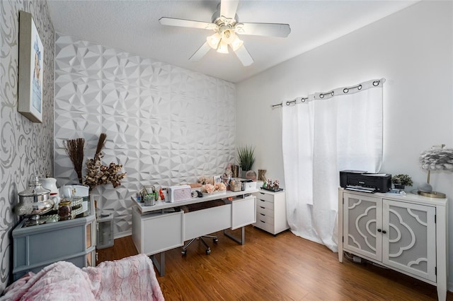 office area with wood-type flooring, a textured ceiling, and ceiling fan