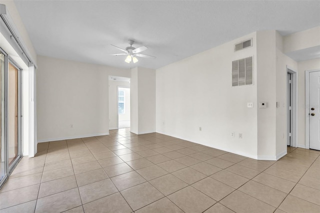 tiled empty room featuring a wealth of natural light and ceiling fan