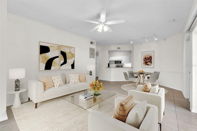 living room featuring light tile patterned floors, track lighting, and ceiling fan