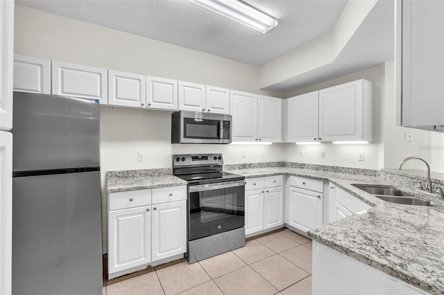 kitchen with sink, stainless steel appliances, white cabinets, and light tile patterned flooring