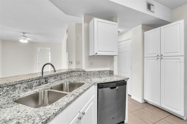 kitchen featuring sink, dishwasher, light stone countertops, white cabinets, and light tile patterned flooring