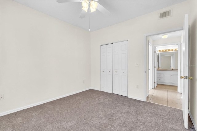 unfurnished bedroom featuring light carpet, ceiling fan, and a closet