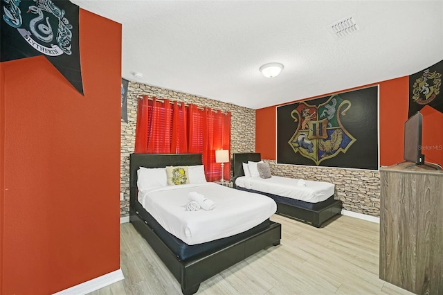 bedroom featuring a textured ceiling and light wood-type flooring