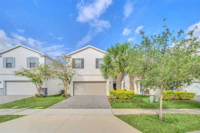 2468 Dubai St, Kissimmee, FL 34747 - view of front facade featuring decorative driveway, an attached garage, stucco siding, and a front lawn
