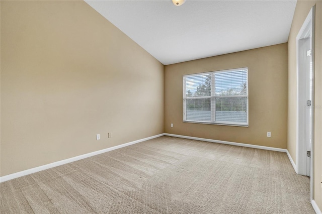 carpeted spare room featuring lofted ceiling