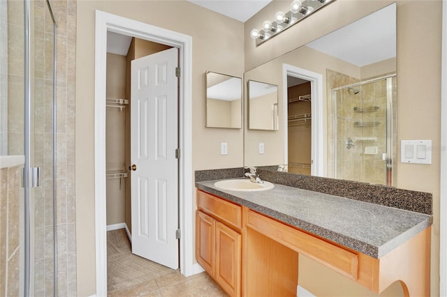 bathroom with tile patterned floors, vanity, and an enclosed shower