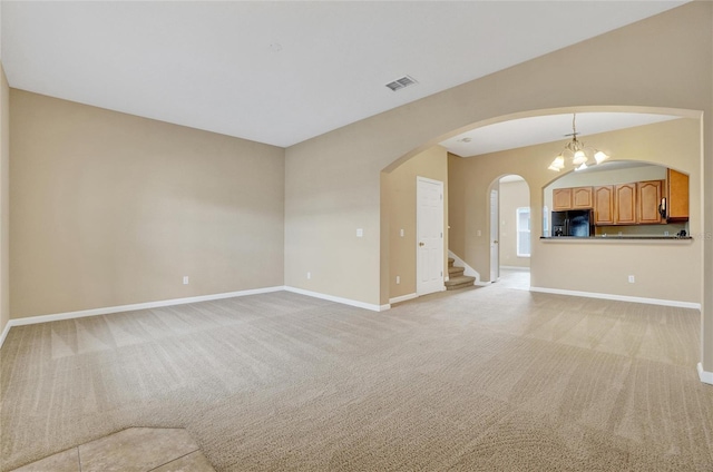 unfurnished living room with light carpet and an inviting chandelier