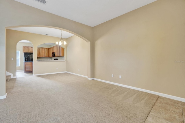 unfurnished living room featuring light colored carpet and a notable chandelier