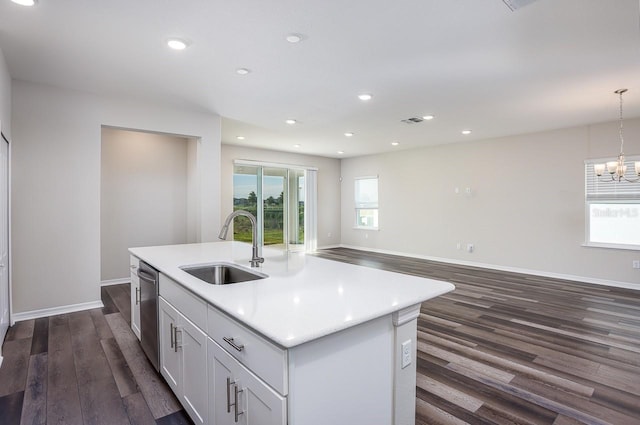 kitchen with dark hardwood / wood-style flooring, a kitchen island with sink, sink, pendant lighting, and white cabinets