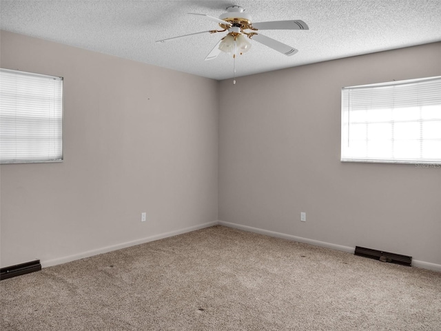 unfurnished room with ceiling fan, plenty of natural light, carpet floors, and a textured ceiling