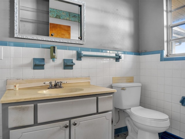 bathroom featuring vanity, toilet, and tile walls