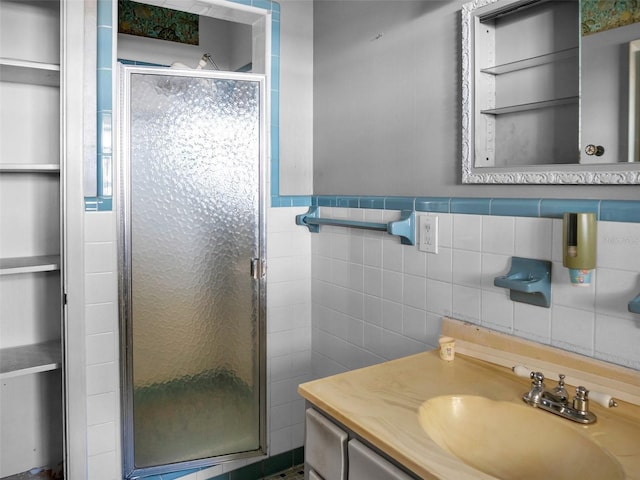 bathroom with vanity, tile walls, and walk in shower