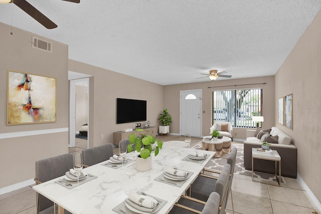 tiled dining room featuring ceiling fan and a textured ceiling