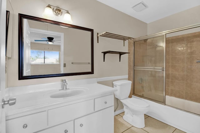 full bathroom with vanity, shower / bath combination with glass door, tile patterned flooring, ceiling fan, and toilet