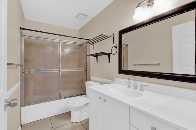 full bathroom with tile patterned floors, vanity, toilet, and bath / shower combo with glass door