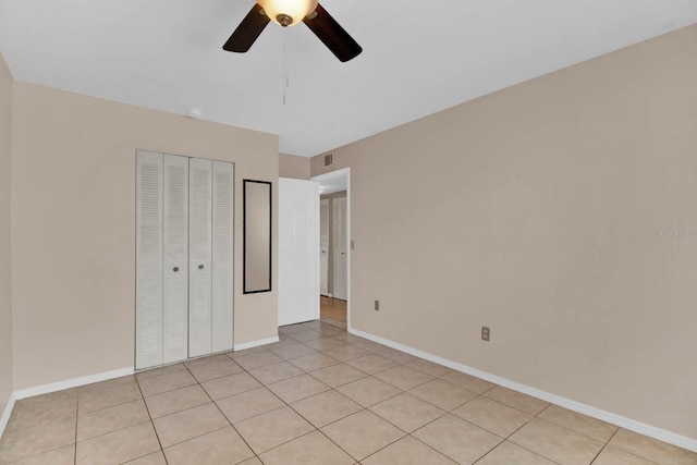 unfurnished bedroom featuring light tile patterned floors, a closet, and ceiling fan